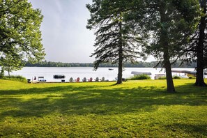 A lakeside view with a grassy area, trees, and boats. - Tiny RV with amazing lake view! (Nevis)