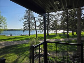 Un espacio al aire libre cubierto con vista a un lago y árboles.