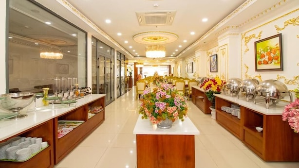 A hotel lobby with a long reception desk, buffet area, and a chandelier. - Anh Thao Hotel Quy Nhơn (Quy Nhon Nam)