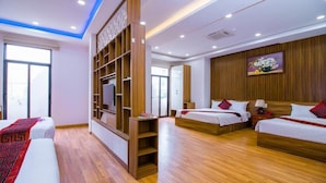 A hotel room with two beds, wooden flooring, a TV on a wooden stand, and a large window. - Anh Thao Hotel Quy Nhơn (Quy Nhon Nam)