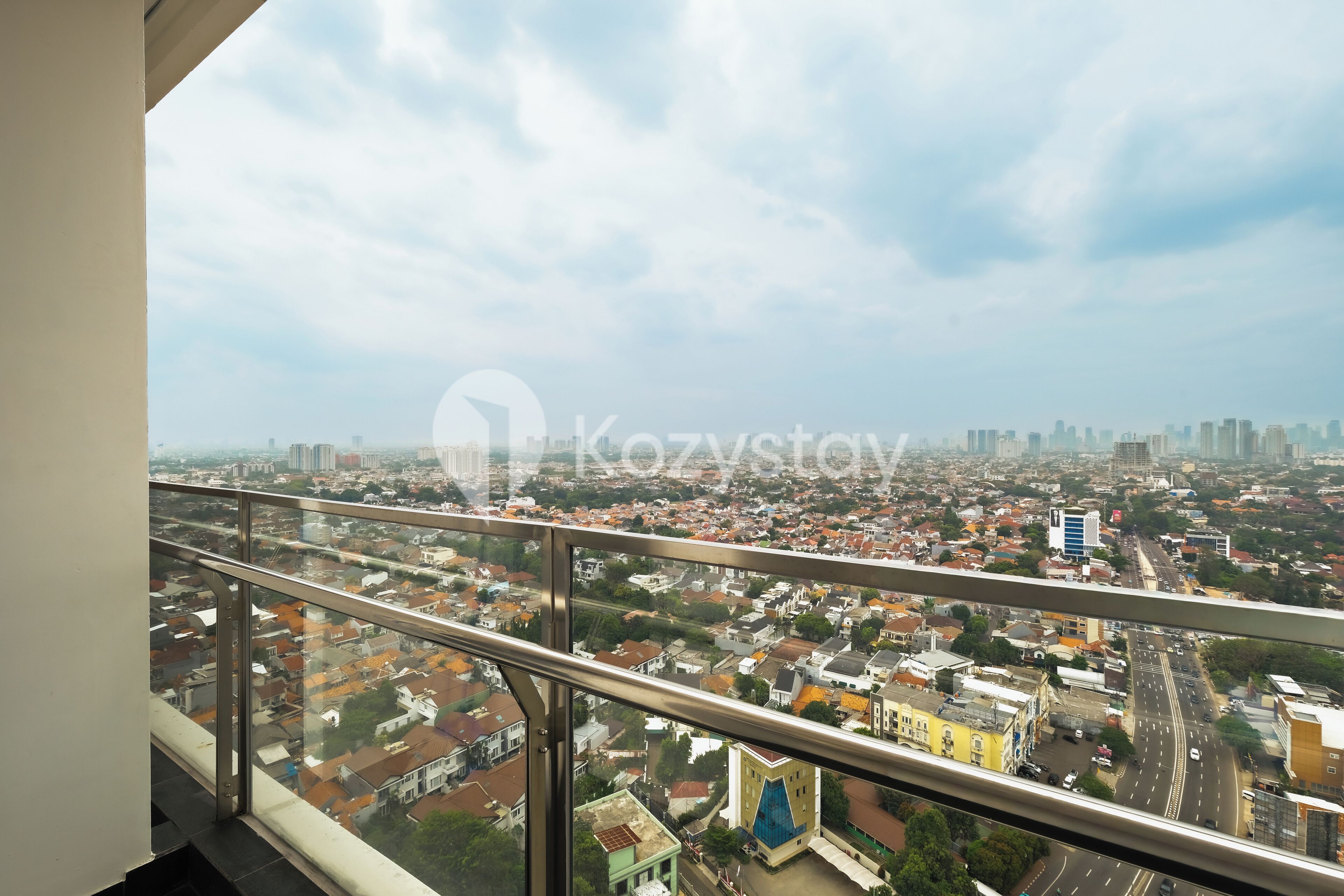 Vista panorámica de la ciudad desde un edificio alto con barandilla metálica.
