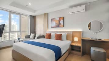 A modern hotel room with a large bed, a desk, a chair, a TV, and a window with a city view.