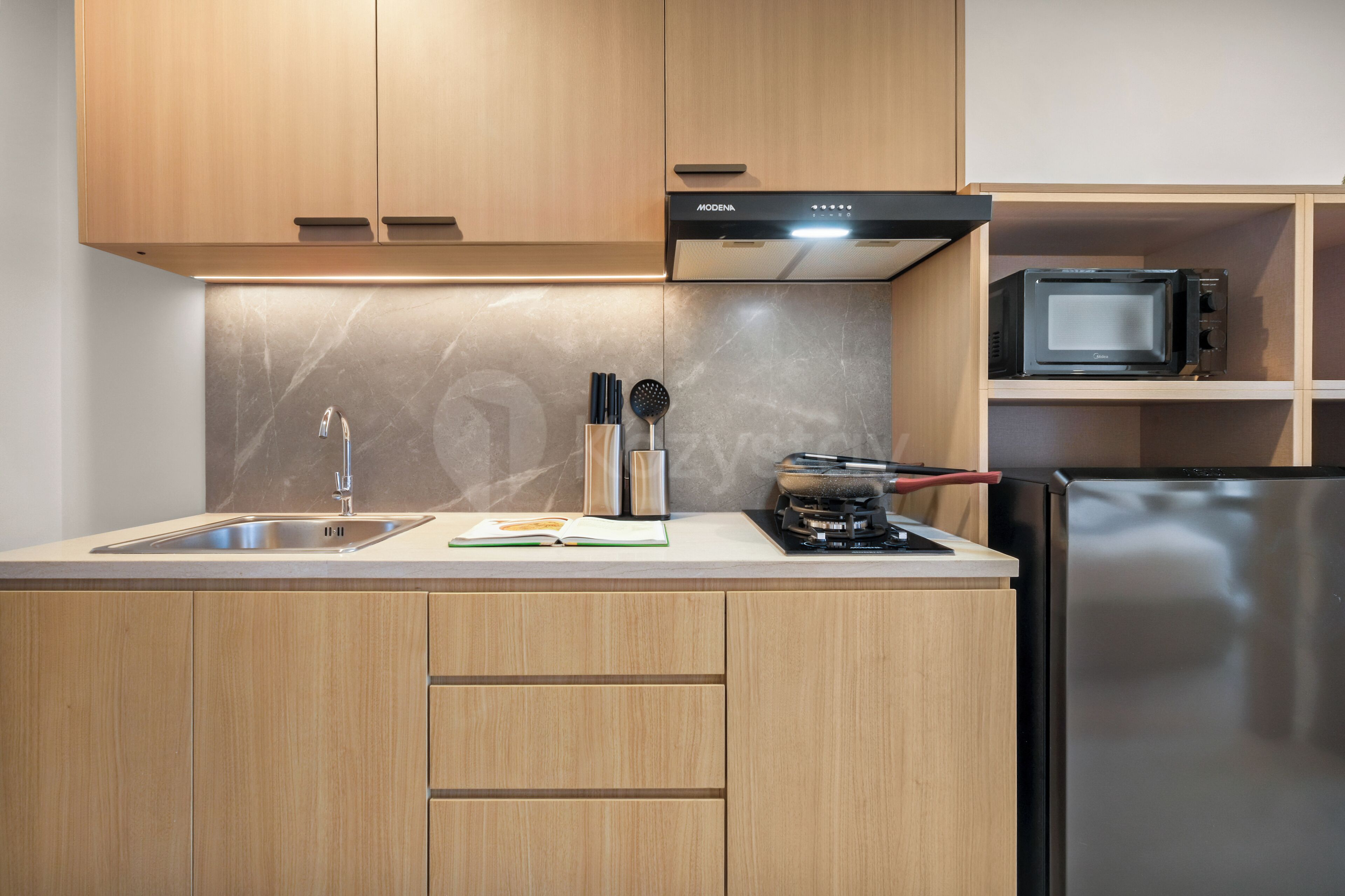 A modern kitchen with wooden cabinets, a stainless steel sink, and a built-in microwave.