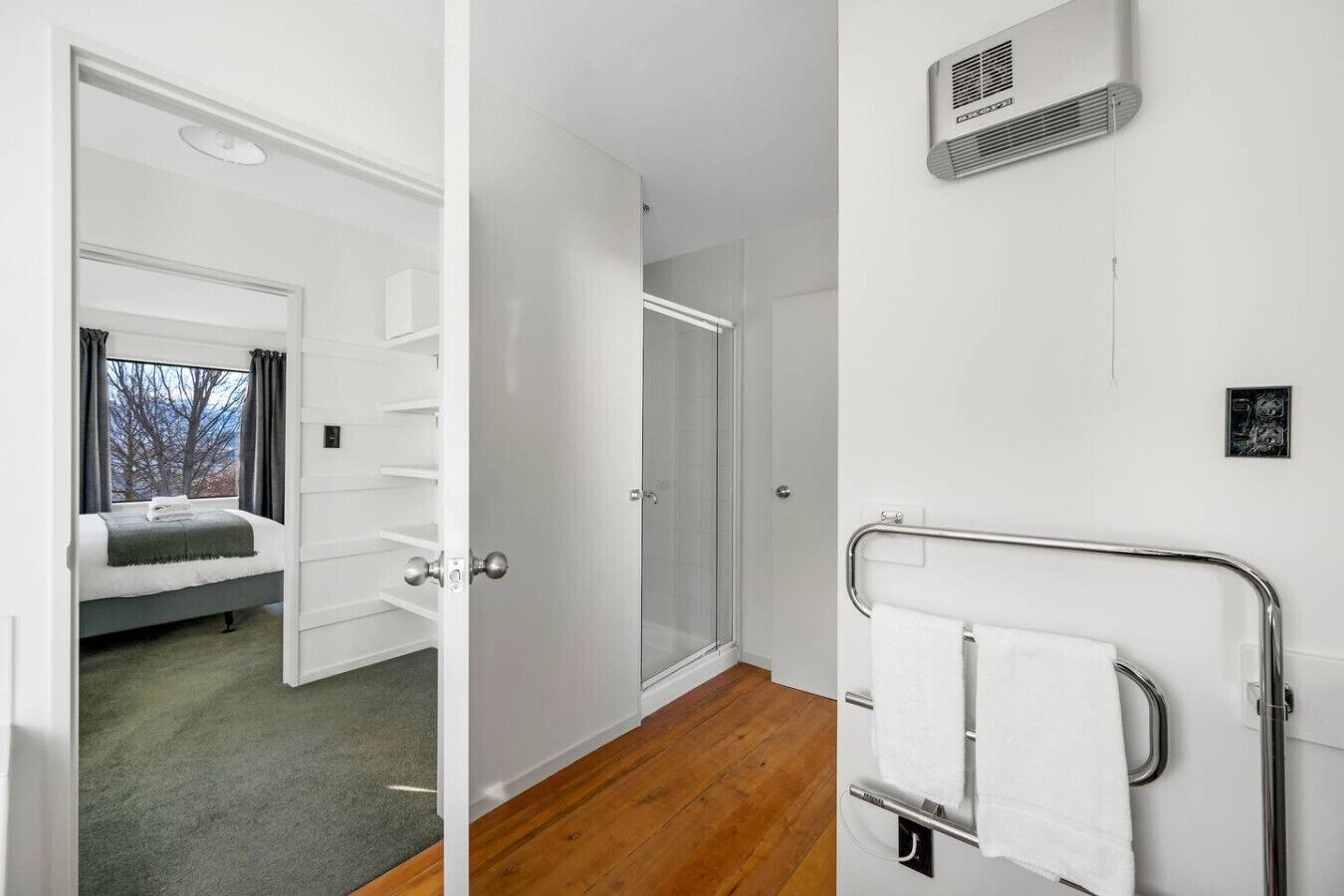 Une chambre d’hôtel avec un lit, une douche et un porte-serviettes.