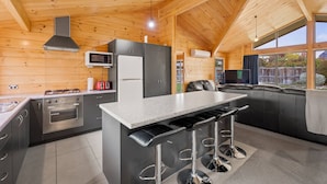 Una cocina moderna con una isla central, electrodomésticos de acero inoxidable y un ventanal grande.