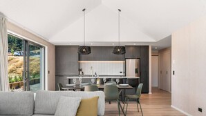 A modern living room with a sofa and a dining area with chairs and a table.