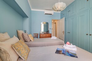 Ein Schlafzimmer mit zwei Betten, einem Schminktisch, einem Spiegel und einem Kleiderschrank.