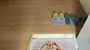 A wooden floor, a dining table, a refrigerator, and slippers.
