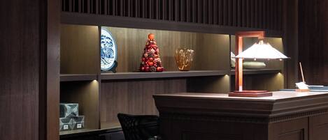 Zona de recepción de un hotel con un mostrador de madera, un árbol de Navidad y un plato decorativo en la pared.