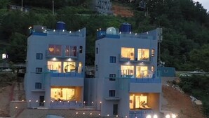 A modern two-story building with multiple balconies and large windows. - Exit Full Villa (Yeongdeok)