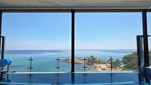 An infinity pool with a clear view of the ocean and a rocky island. - Exit Full Villa (Yeongdeok)