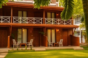 A two-story wooden building with a balcony, multiple doors, and outdoor seating. - Wild Roots Mirissa (Mirissa, Sri Lanka)