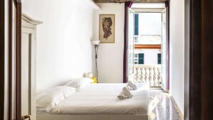Ein Hotelzimmer mit Bett, einem Bild an der Wand und einem Balkon mit Geländer.