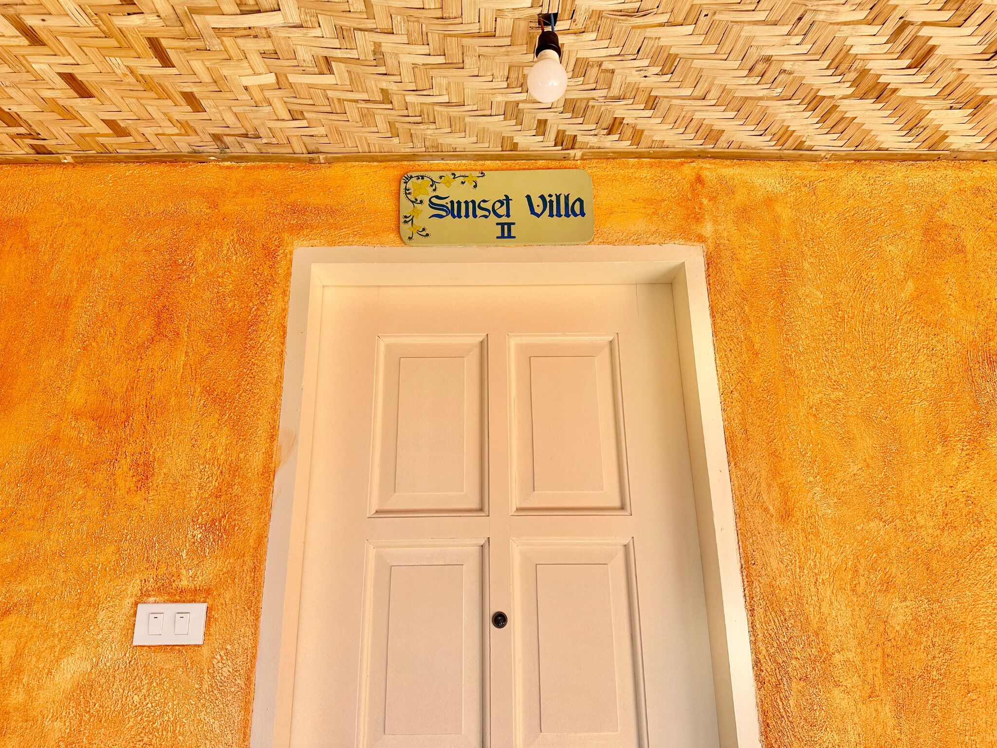 Una puerta blanca con un letrero que dice "Sunset Villa III".