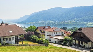 A residential area with houses, a lake, and mountains in the background.