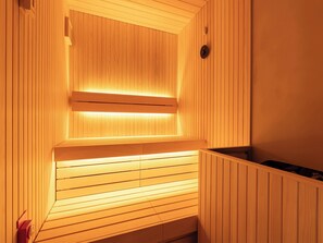 Sauna, jossa on puupanelointi ja penkki.