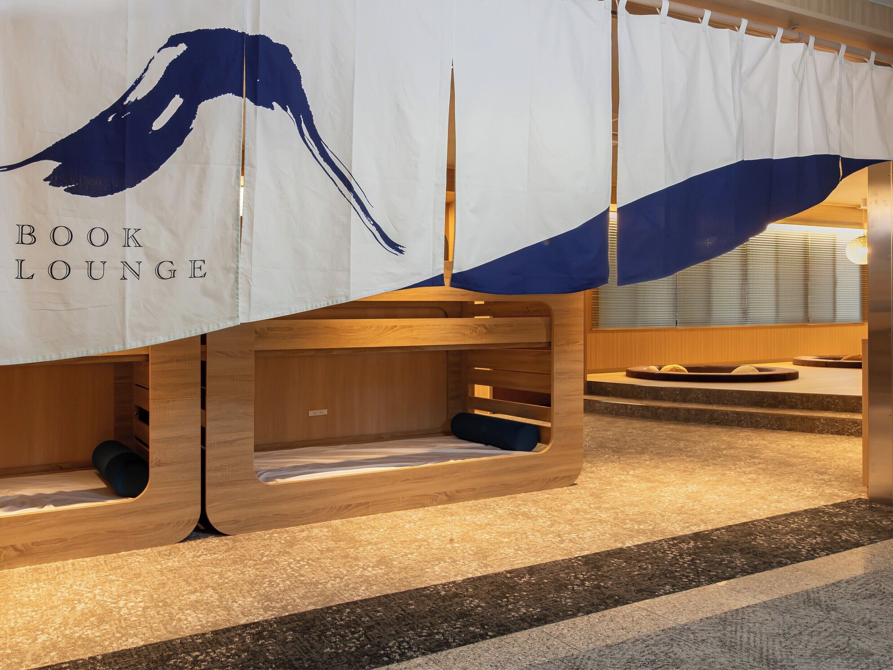 A book lounge area with wooden benches and a banner reading 'BOOK LOUNGE'.