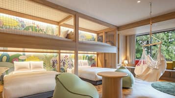 Un dormitorio con varios niveles, camas individuales superpuestas, una silla colgante y una mesa redonda.