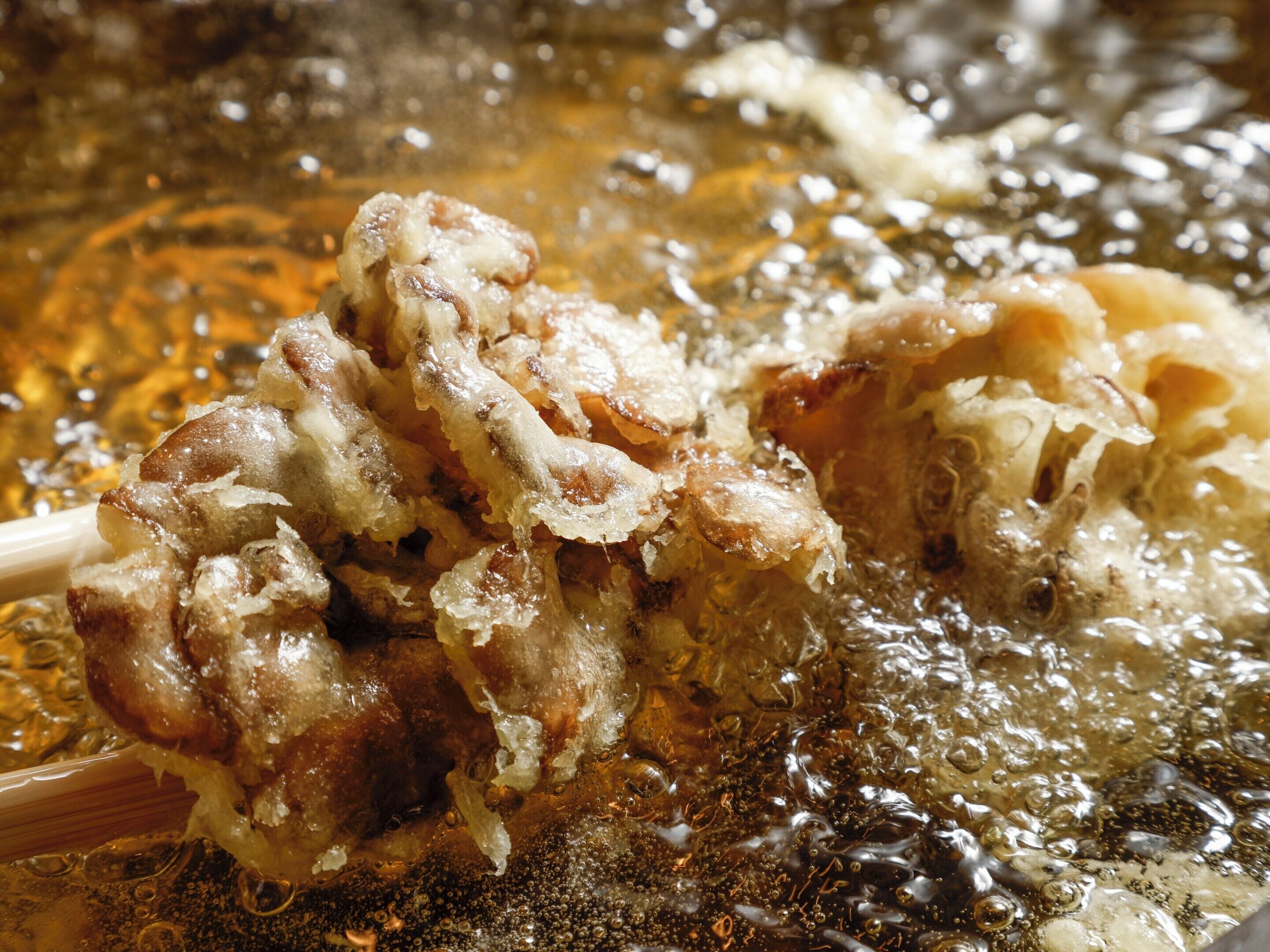 A close-up of food being fried in hot oil.
