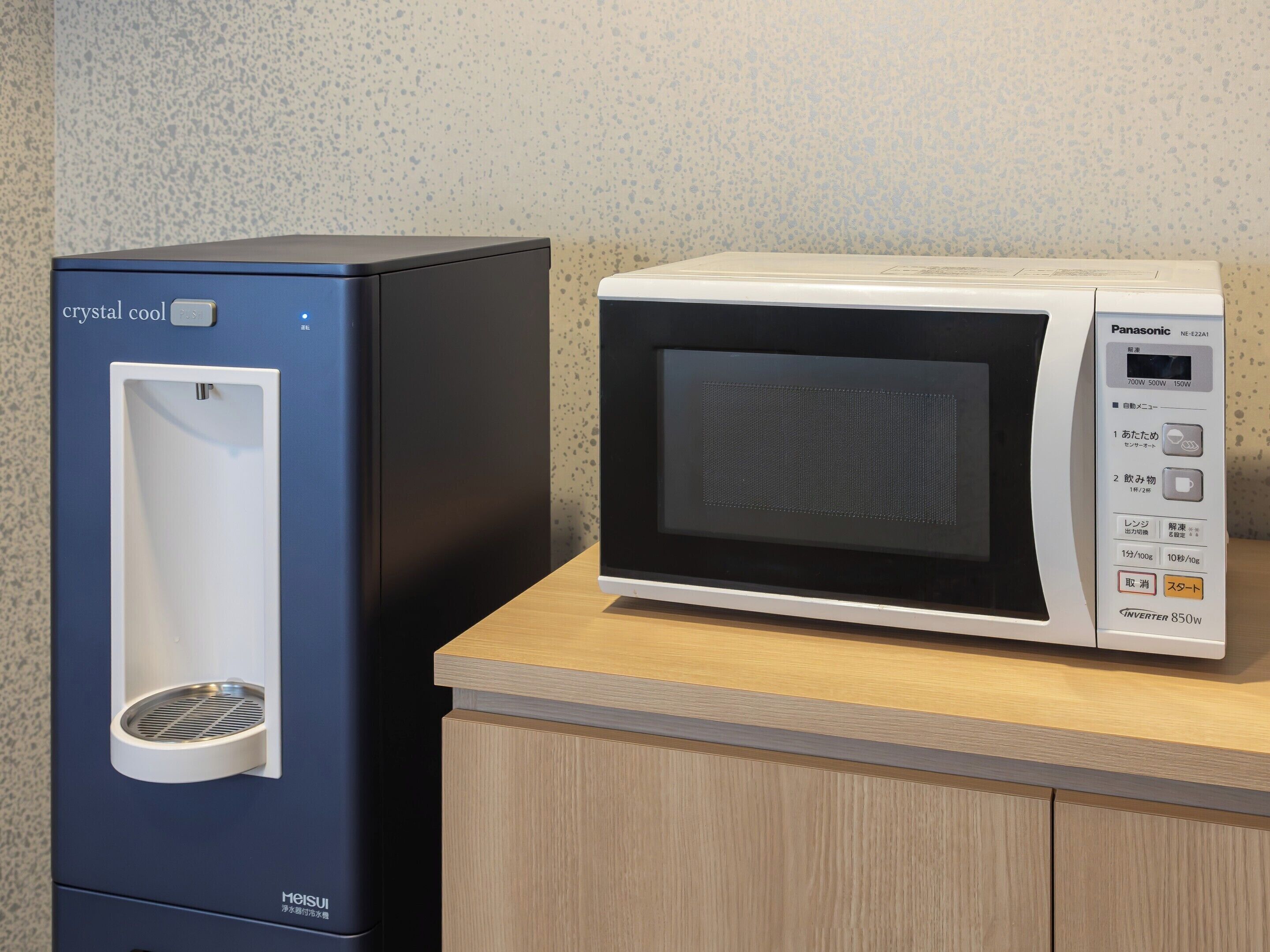 A compact refrigerator and a microwave on a countertop.