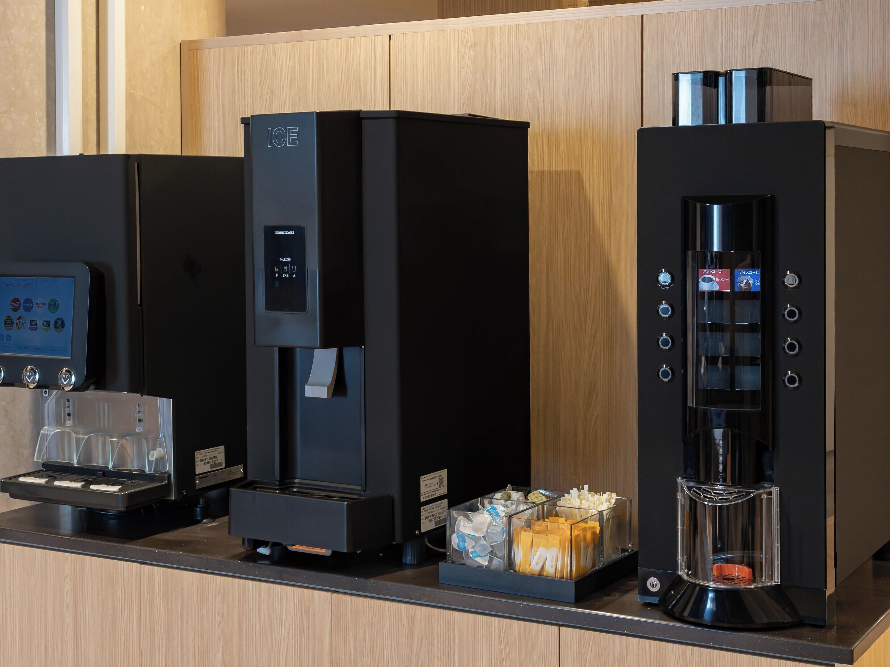 A coffee machine, a beverage dispenser, and a coffee maker on a counter.