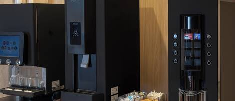 A coffee machine, a beverage dispenser, and a coffee maker on a counter.
