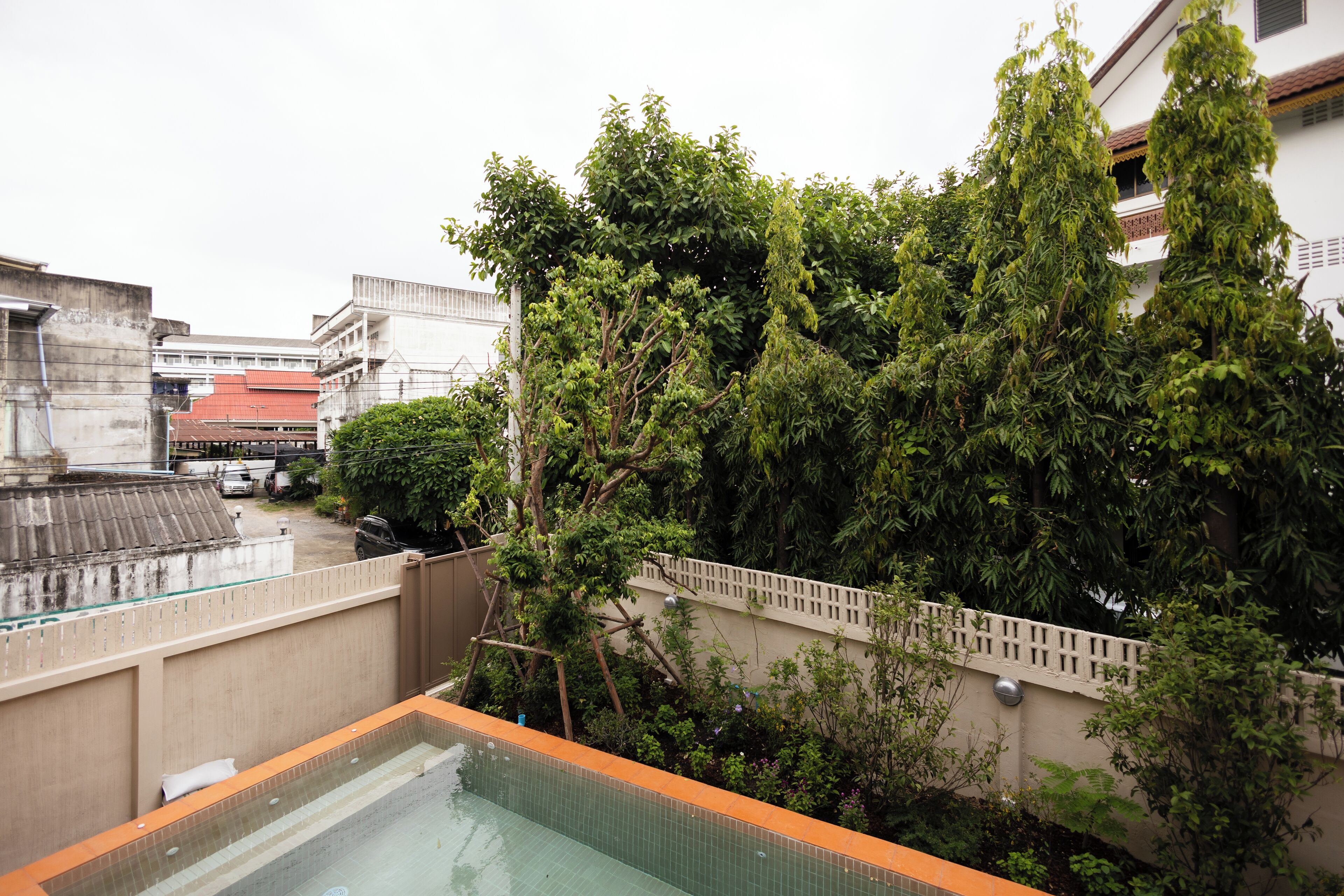 A rooftop pool with a view of surrounding buildings and trees.