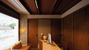 Zona de recepción de un hotel con un mostrador de madera, una computadora, un globo terráqueo y una silla.