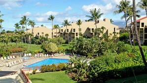 Un resort con piscina, palmeras y vistas a la montaña.
