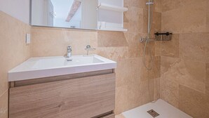 A bathroom with a white sink, a mirror, a shower, and a wooden vanity. - IN THE HEART OF THE TOWN CENTRE – STUDIO – CLOSE TO THE BEACH (STE MAXIME)