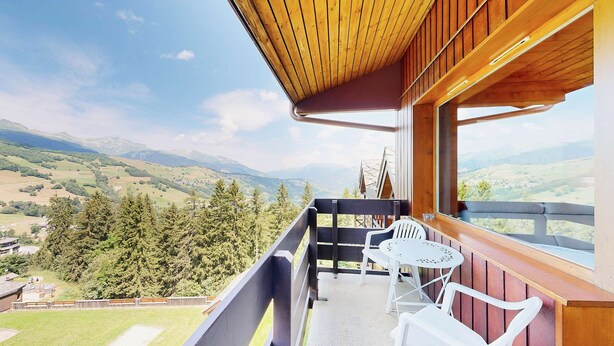 A balcony with a wooden ceiling overlooking a mountainous landscape. - Cheval Blanc 32 - Crève Coeur (LES AVANCHERS VALMOREL)