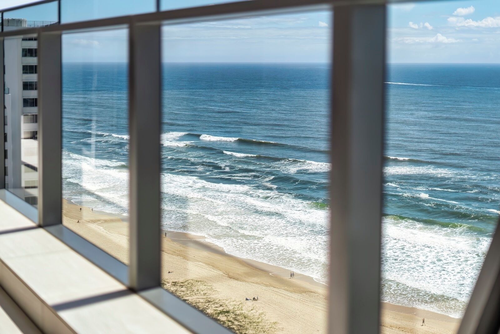A view of the ocean from a high-rise building with large windows.