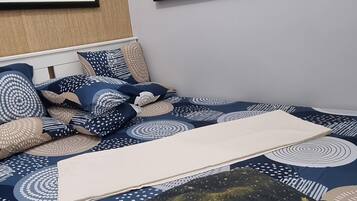Een moderne slaapkamer met een bed, kussens en twee ingelijste kunstwerken aan de muur.