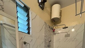 A bathroom with a sink, toilet, and shower. - Green Leaf Regency  (Kolkata)