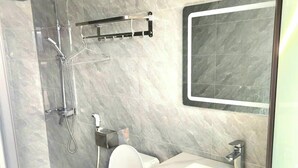 A modern bathroom with a glass-enclosed shower, a white toilet, and a vanity with a mirror. - Loc Phat Hotel MC - by BAY LUXURY (Moc Son)