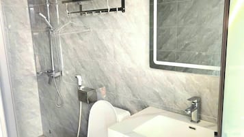 Habitación básica, vistas a la ciudad | Baño | Ducha, artículos de higiene personal gratuitos y secador de pelo