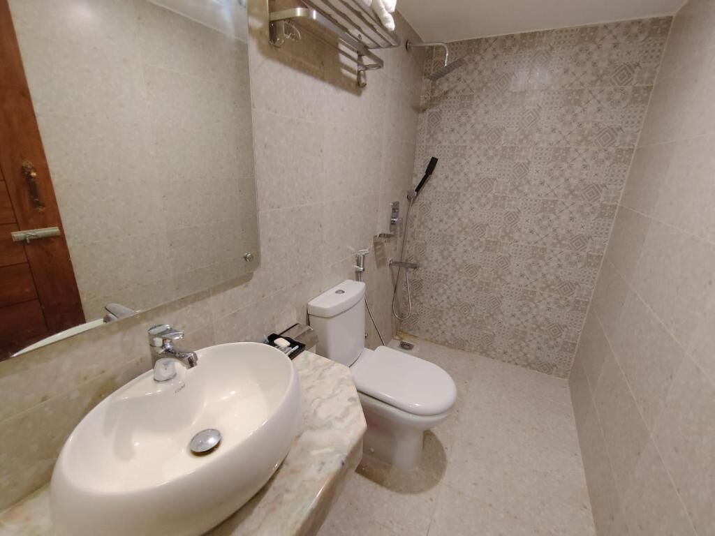 Een badkamer met een wastafel, toilet en douche.