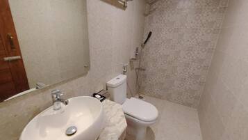 A bathroom with a sink, toilet, and shower.