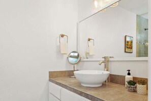 A bathroom with a white sink, a mirror, and a towel rack. - Saltwater Pool & Spa, Fire Pit, Expansive Mountain View (Palm Springs)
