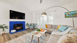 Un salon moderne avec une cheminée, un téléviseur à écran plat, un canapé et une table basse.