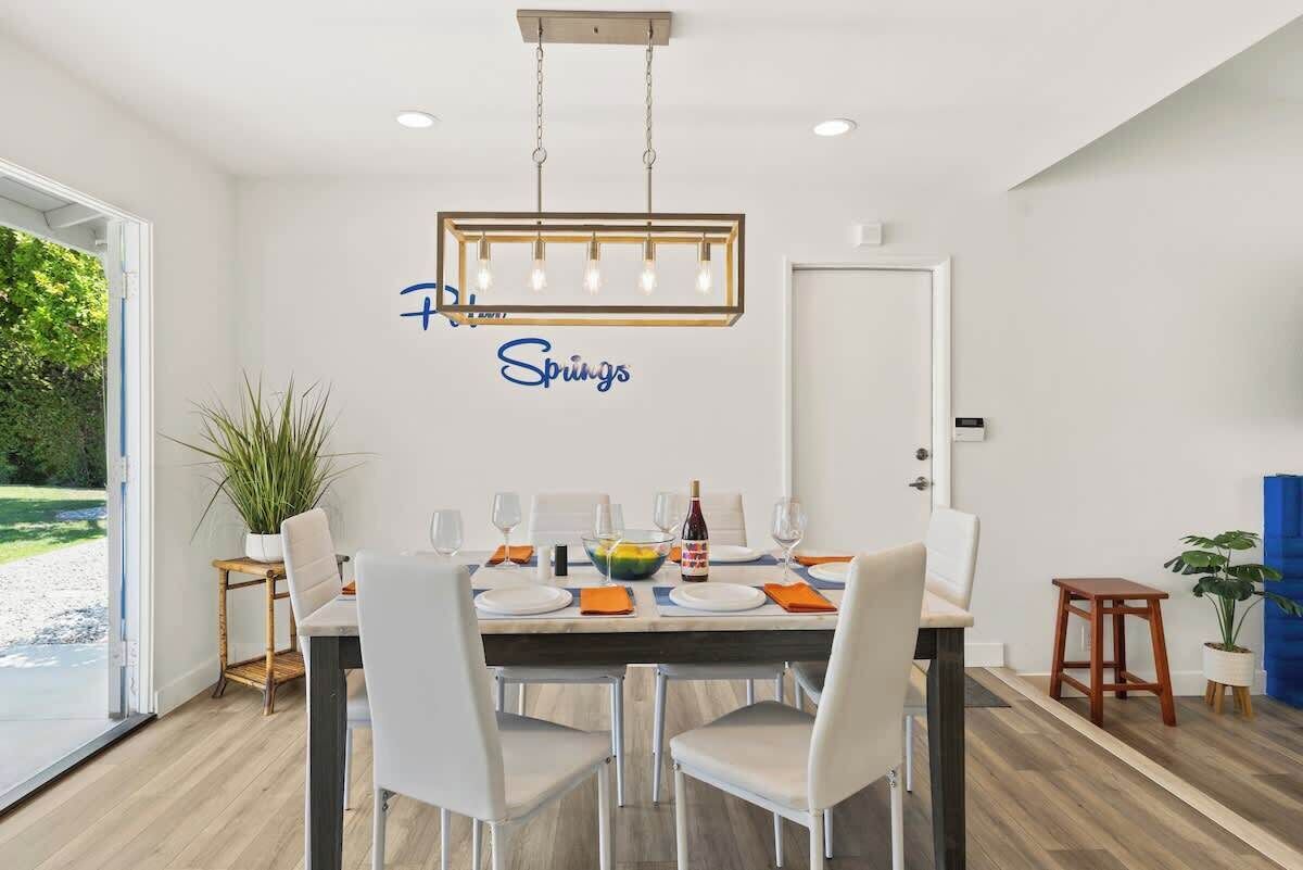 A dining area with a table set for four, a chandelier, and a wall sign that reads 'Springs.'