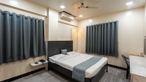 A modern hotel room with a bed, bedside table, and a desk. - Hotel Ellora Park (Pune)