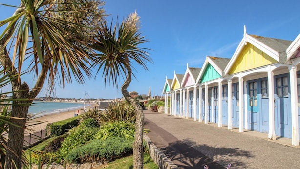 A row of colorful seaside cottages with a beach view. - Beachcomb (Weymouth)
