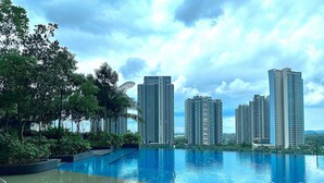Una piscina con vistas a rascacielos y zonas verdes.