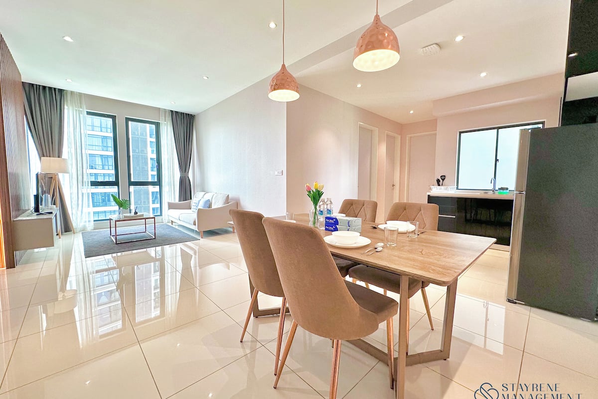 A modern dining area with a wooden table, two chairs, and pendant lighting.