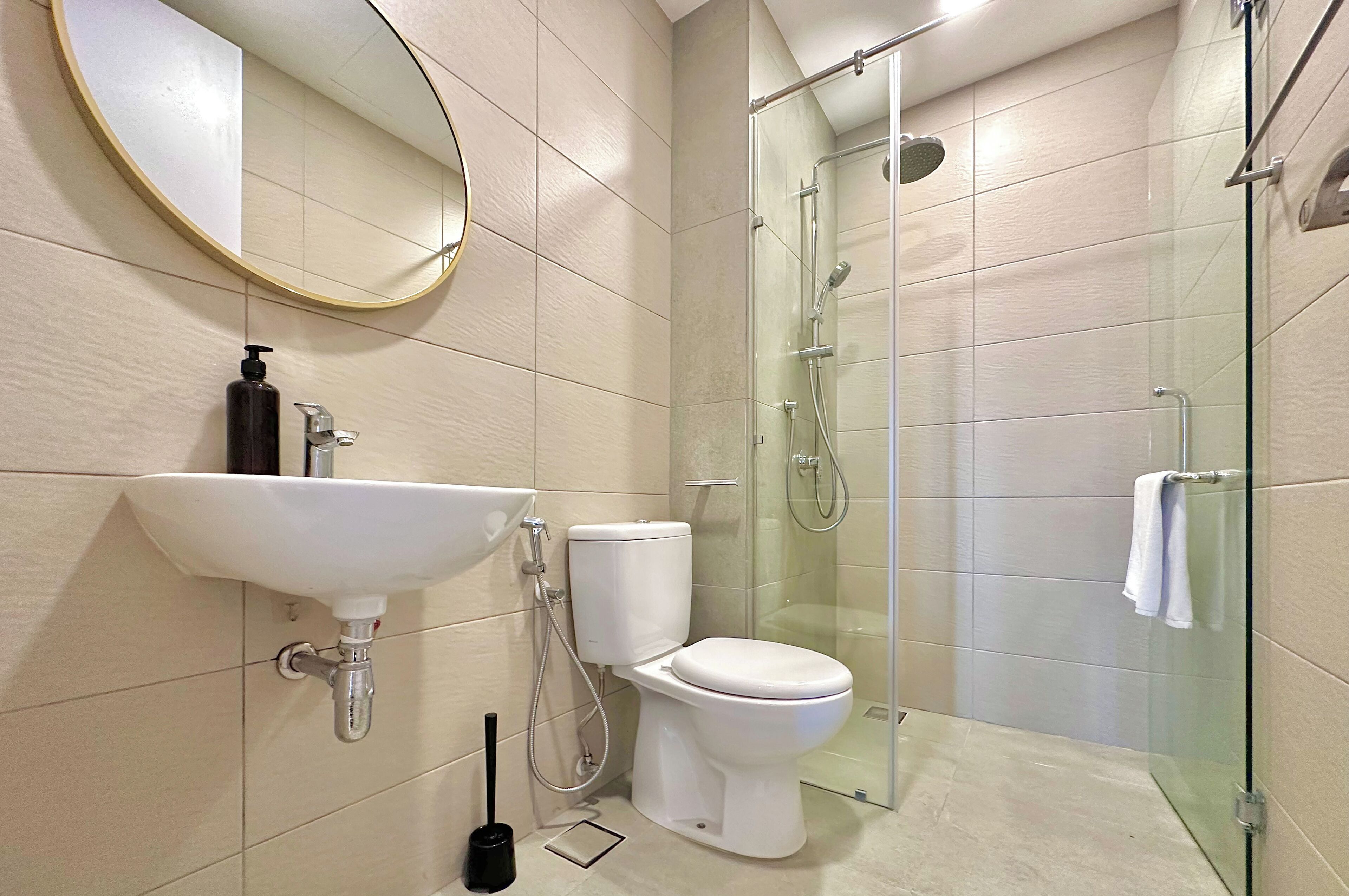 A modern bathroom with a toilet, sink, and glass-enclosed shower.