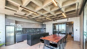 Una cocina moderna con una isla central, electrodomésticos integrados y una gran mesa de comedor con sillas.