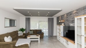 Ein modernes Wohnzimmer mit Sofa, Couchtisch und TV-Möbel.