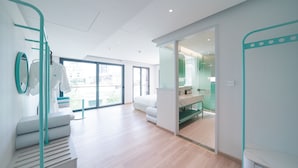 A modern hotel room with a staircase, a large window, and a view of the city. - IconSphere Hotel (Ho Chi Minh City)
