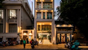 A multi-story building with a modern architectural design, featuring a prominent entrance and a visible staircase leading to the ground floor. - IconSphere Hotel (Ho Chi Minh City)